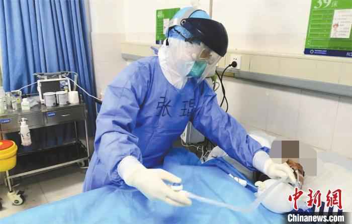 资料图:医护人员精心照料躺在病床上的诸某。张驰 摄  新冠肺炎ICU病房医生:生死时刻,和患者几乎口鼻相对