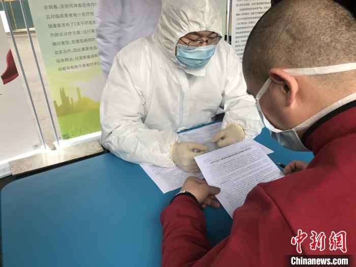 新冠肺炎恢复期血浆捐献者在阅读《成都市血液中心新冠肺炎康复者恢复期血浆捐献知情同意书》并签字确认。 吕杨 摄  四川第三位、第四位新冠肺炎康复者捐献恢复期血浆