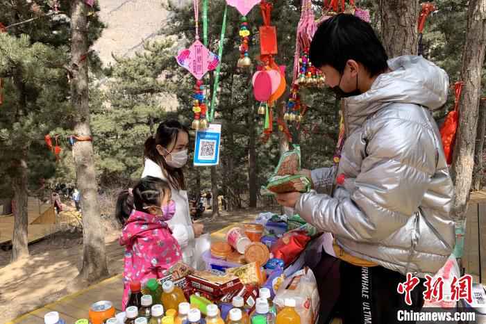 游客在景区商铺购买食品。 李佩珊 摄  贺兰山间春风起 游客理性踏青游