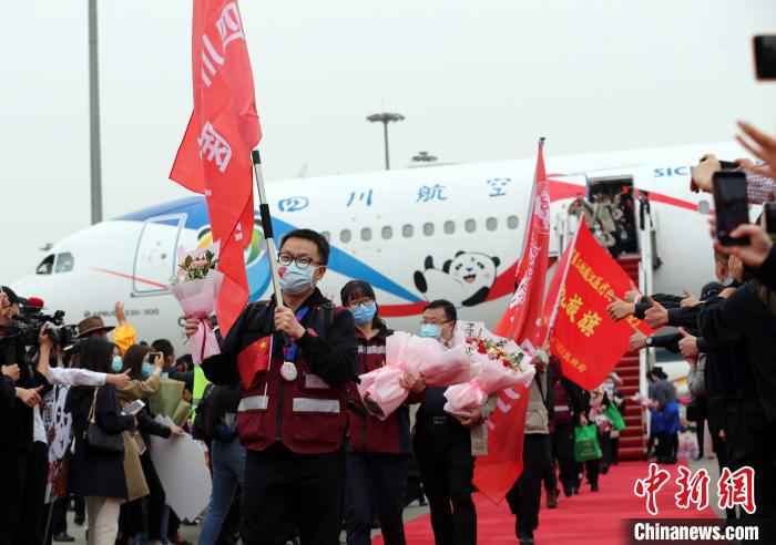 机舱打开,医护人员走下飞机。 王磊 摄  最后一批援湖北“白衣川军”归家:“一个都没有少”