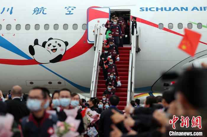 机舱打开,医护人员走下飞机。 王磊 摄  最后一批援湖北“白衣川军”归家:“一个都没有少”